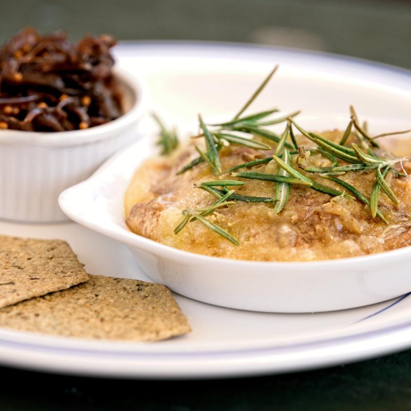 A Baked Bluebell, topped with Rosemary and served with crackers and preserves